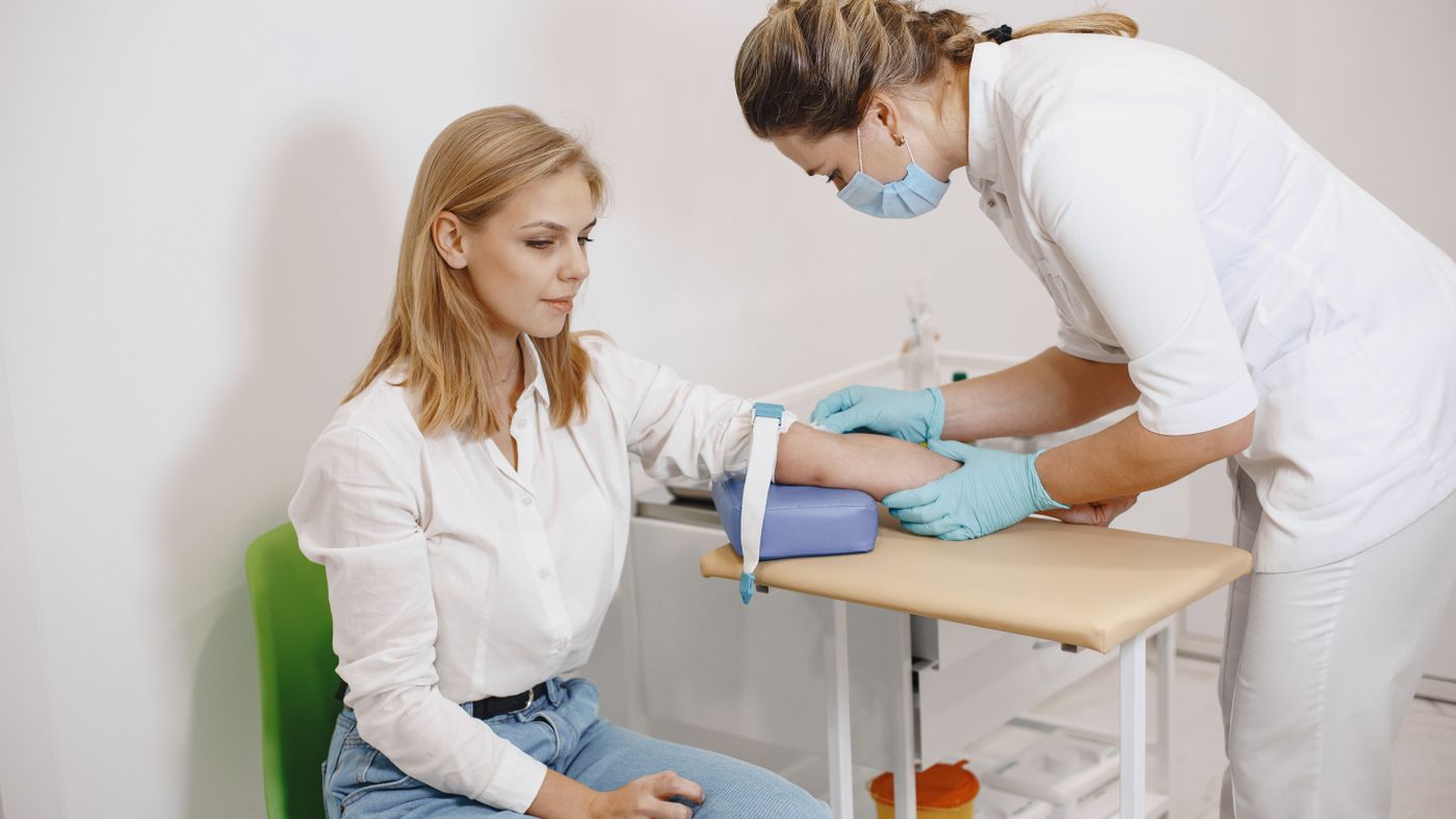 Profesional de laboratorio tomando una muestra de sangre a una persona